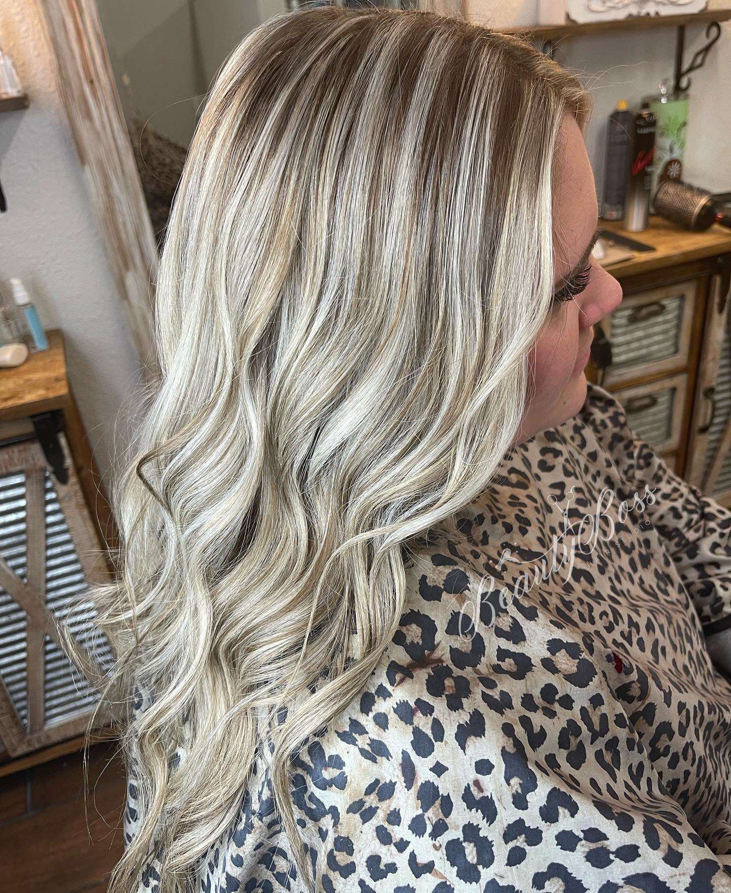 Icy blonde highlights through a darker base, styled in soft waves, in the Beauty Boss studio